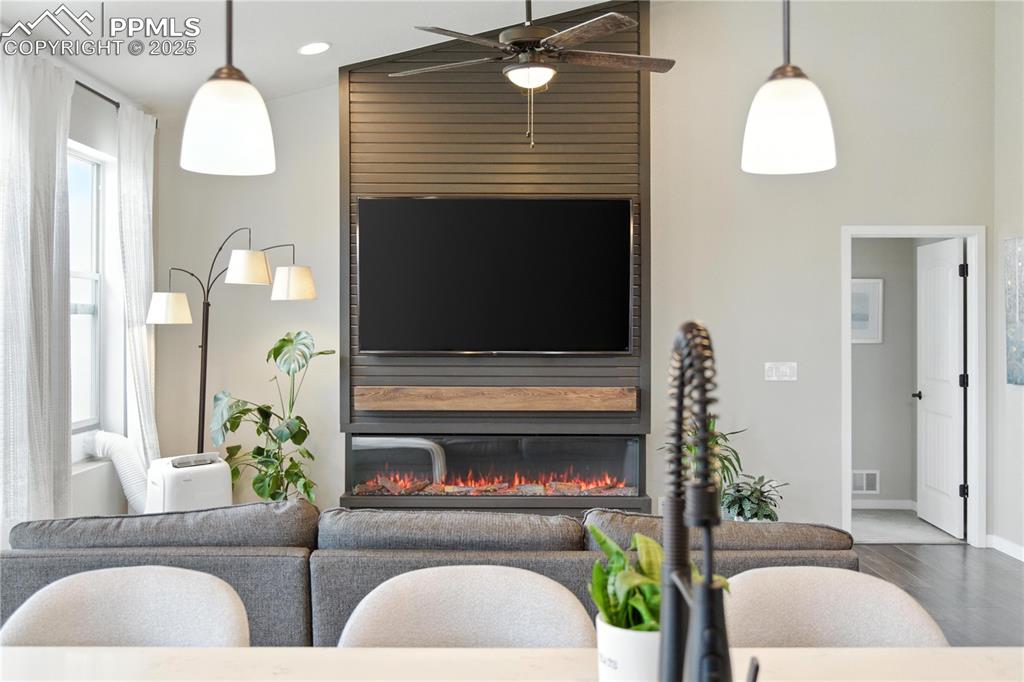 Image 10 of 40: Living room featuring wood finished floors, a glass covered fireplace, ceil