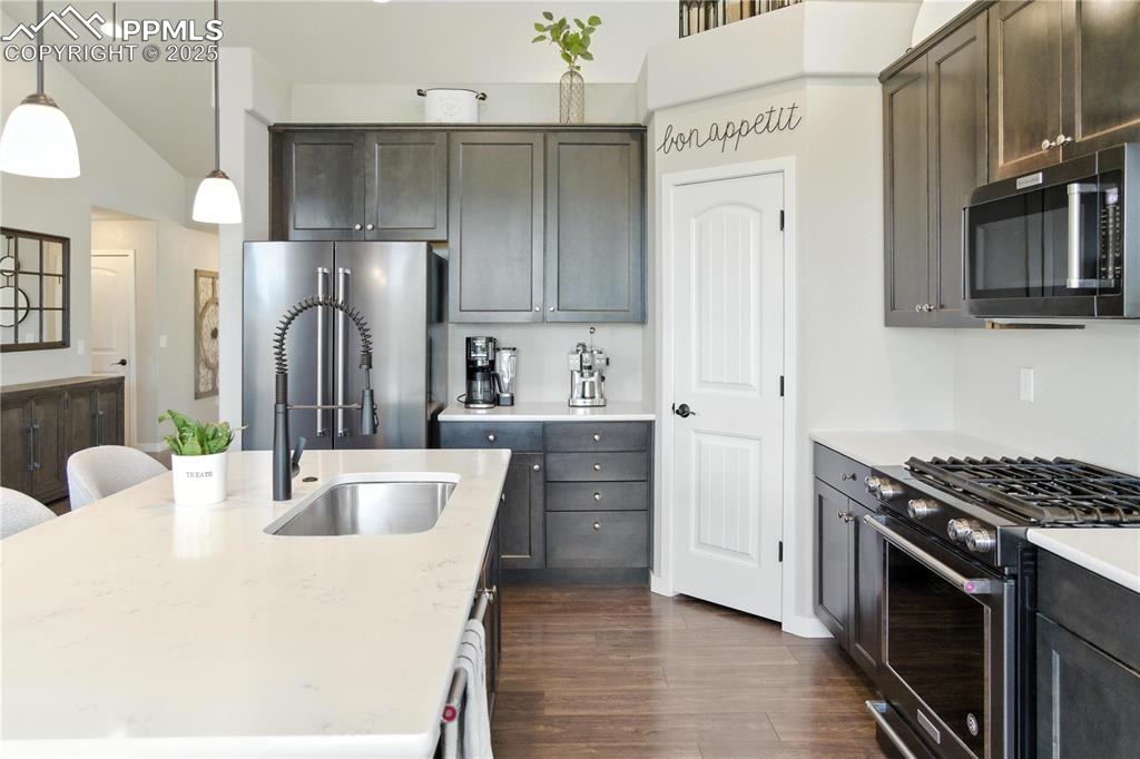 Image 12 of 40: Kitchen with appliances with stainless steel finishes, a kitchen island wit