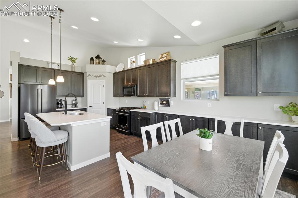 Image 16 of 40: Kitchen with high end appliances, vaulted ceiling, a kitchen island with si