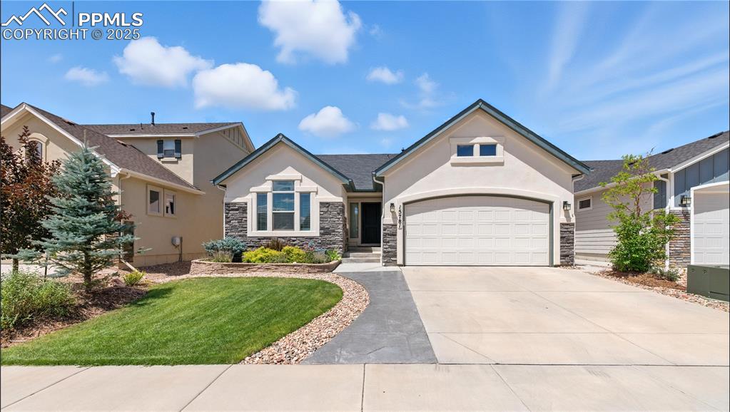 Image 2 of 40: View of front of property with concrete driveway, a garage, stucco siding,