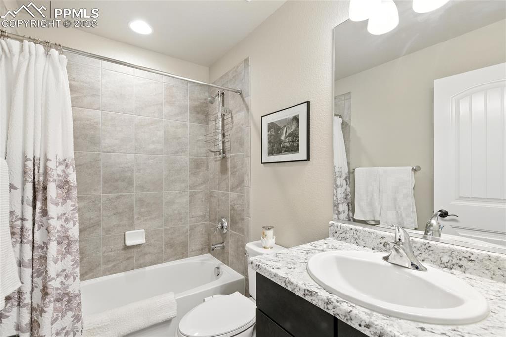Image 22 of 40: Main Level Bathroom with vanity and shower / bathtub combination with curta