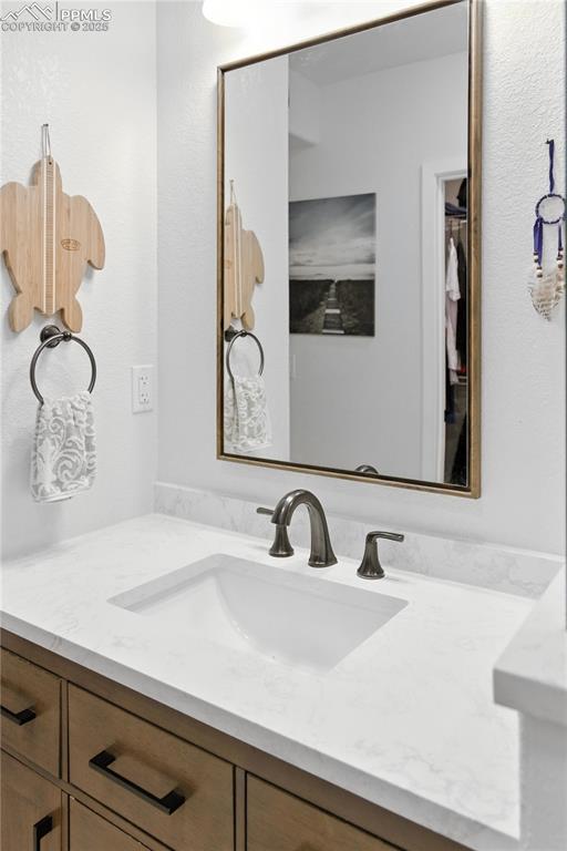 Image 30 of 40: Bathroom featuring vanity and a walk in closet