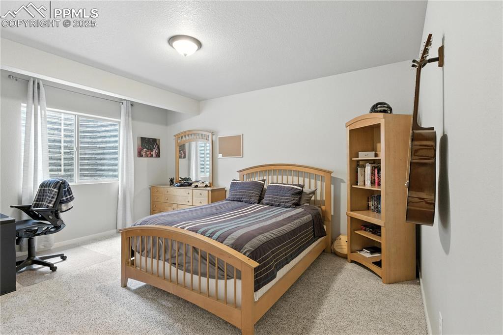 Image 32 of 40: Carpeted bedroom with baseboards and a textured ceiling