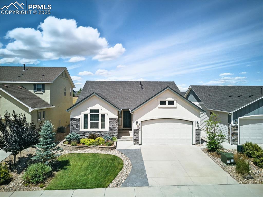 Image 39 of 40: View of front of property featuring an attached garage, driveway, stone sid