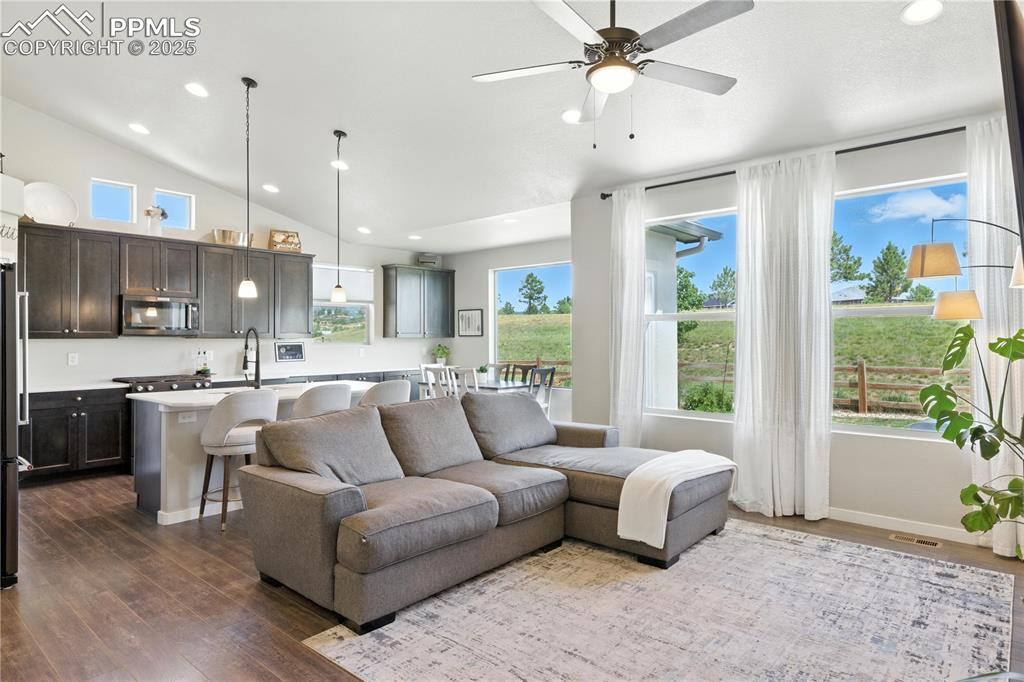 Image 6 of 40: Living area with recessed lighting, dark wood finished floors, lofted ceili