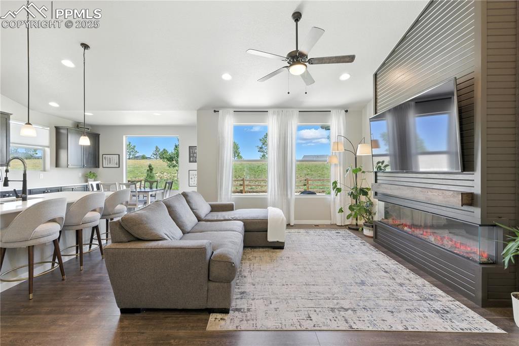 Image 9 of 40: Living area featuring ceiling fan, dark wood finished floors, recessed ligh