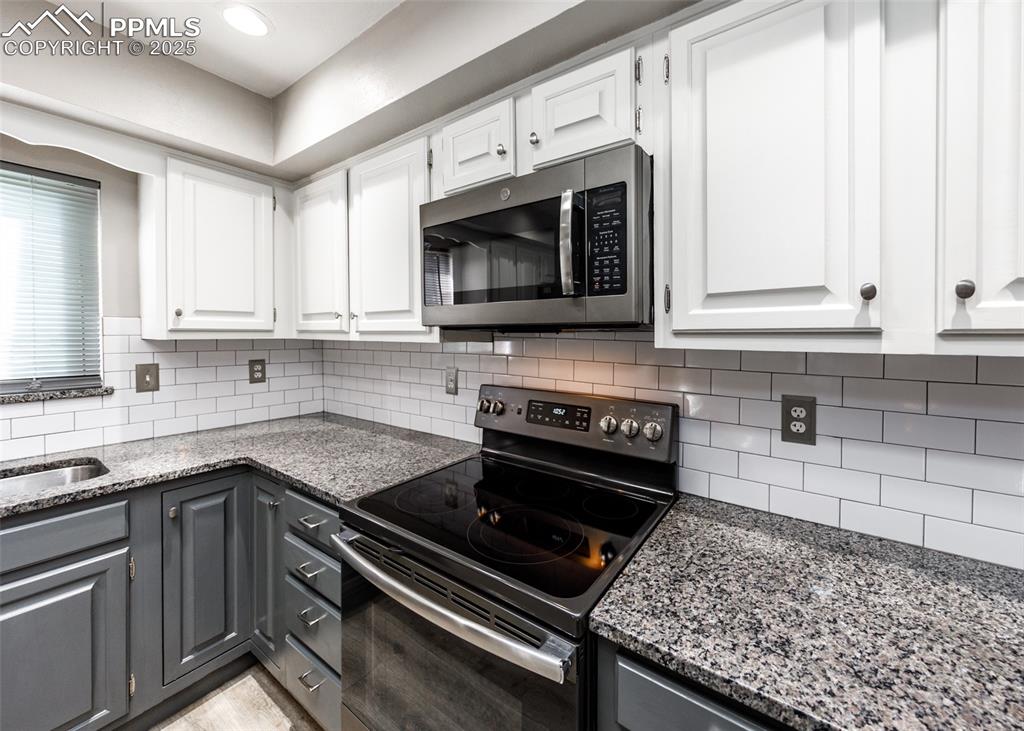 Image 12 of 50: Close up of Range and Microwave in Kitchen