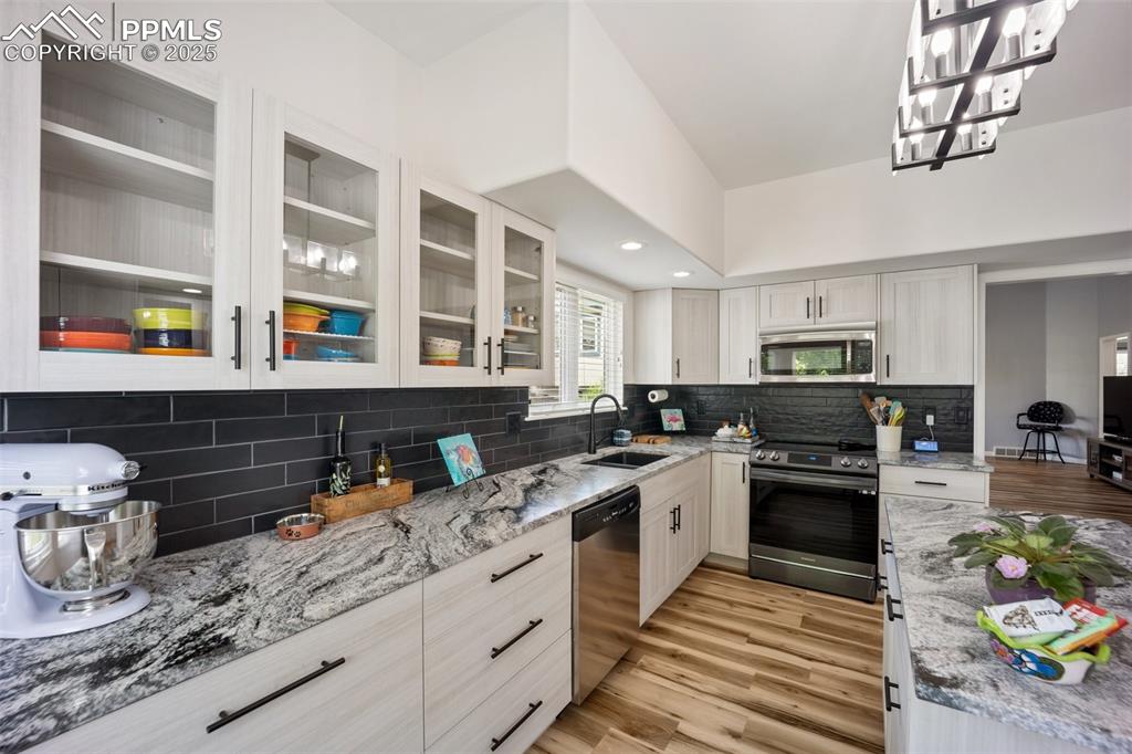 Image 13 of 50: Kitchen featuring stainless steel appliances, light wood-style flooring, li