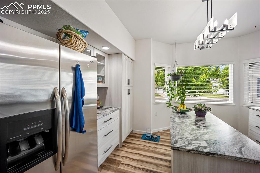 Image 16 of 50: Kitchen featuring stainless steel fridge with ice dispenser, light wood-sty