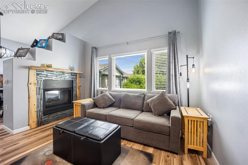 Image 17 of 50: Living area featuring a multi sided fireplace, wood finished floors, and lo