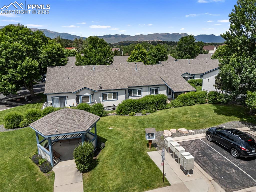 Image 47 of 50: Single story home with uncovered parking, a front lawn, a mountain view, an