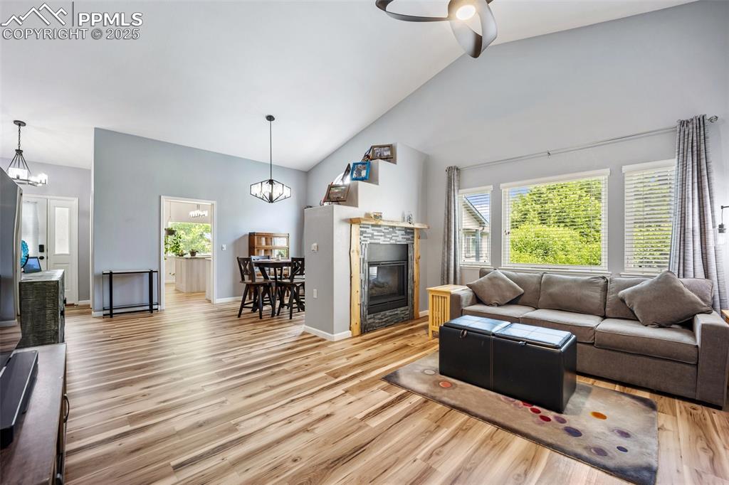Image 5 of 50: Living room featuring a chandelier, light wood-type flooring, a glass cover