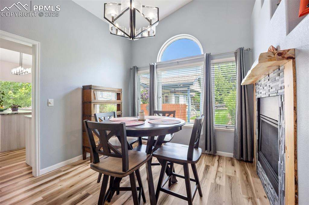 Image 9 of 50: Dining space featuring a chandelier, high vaulted ceiling, light wood finis