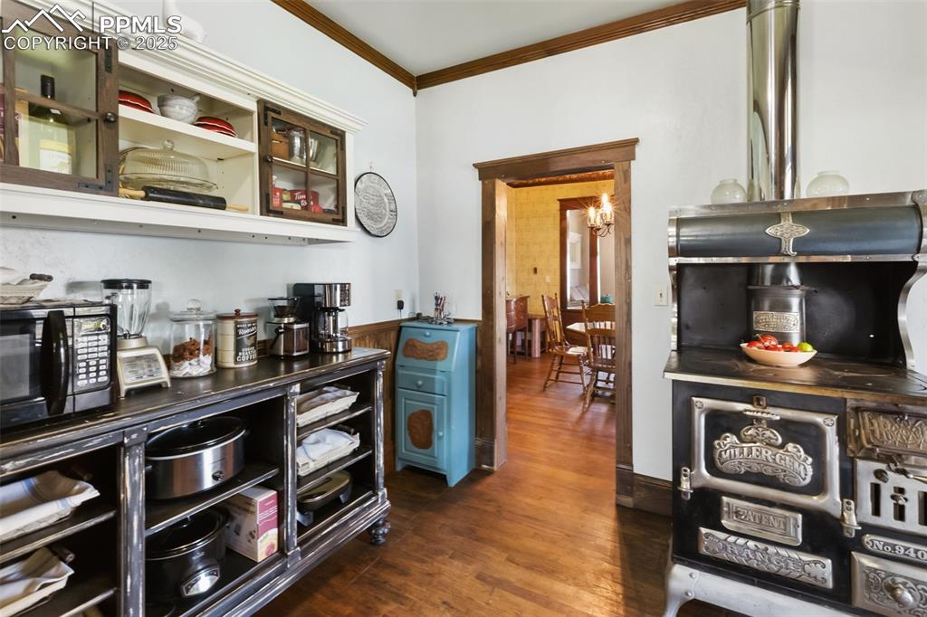 Image 15 of 43: easterly potion, looking in to dining room ornate wood stove is functional