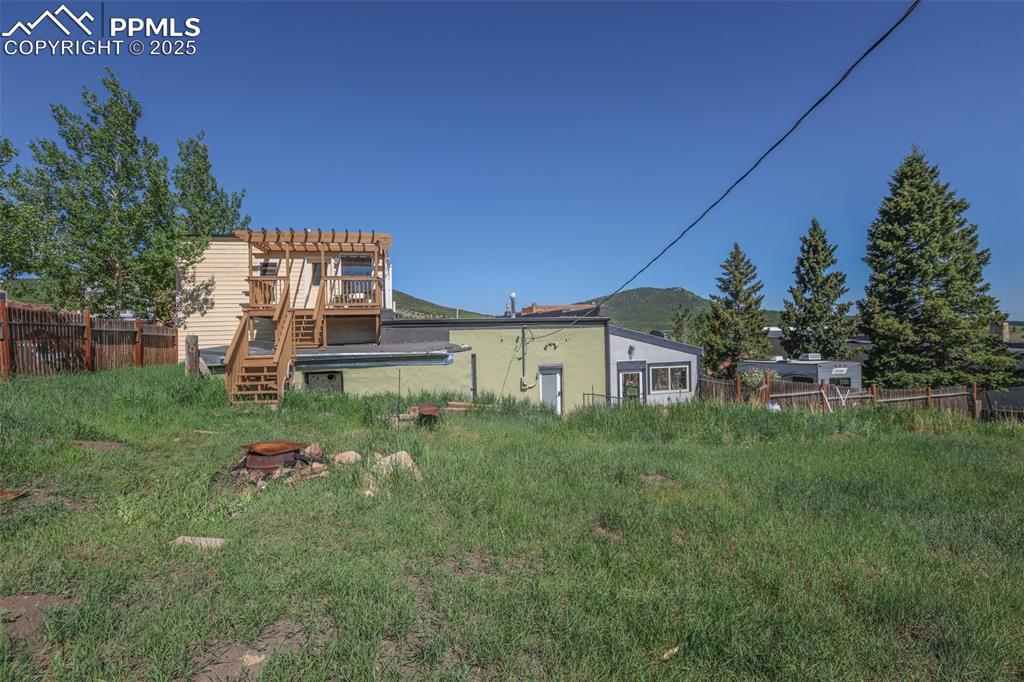 Image 4 of 43: from the yard, looking east, stairs lead to deck off of the bedroom/bath ov