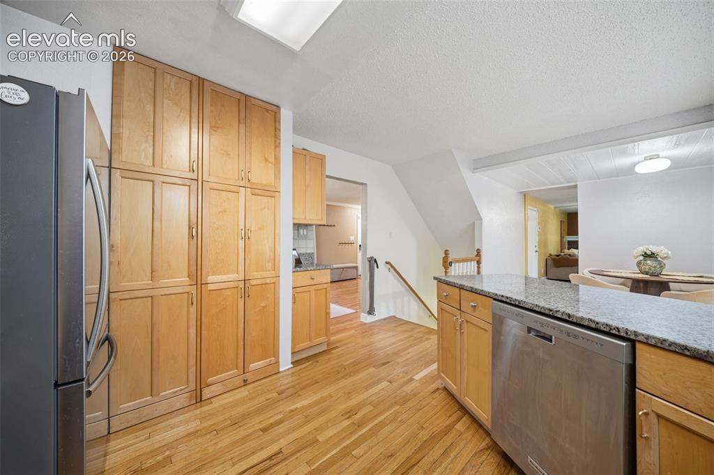 Image 14 of 42: Kitchen featuring light wood cabinetry and wood-finish flooring