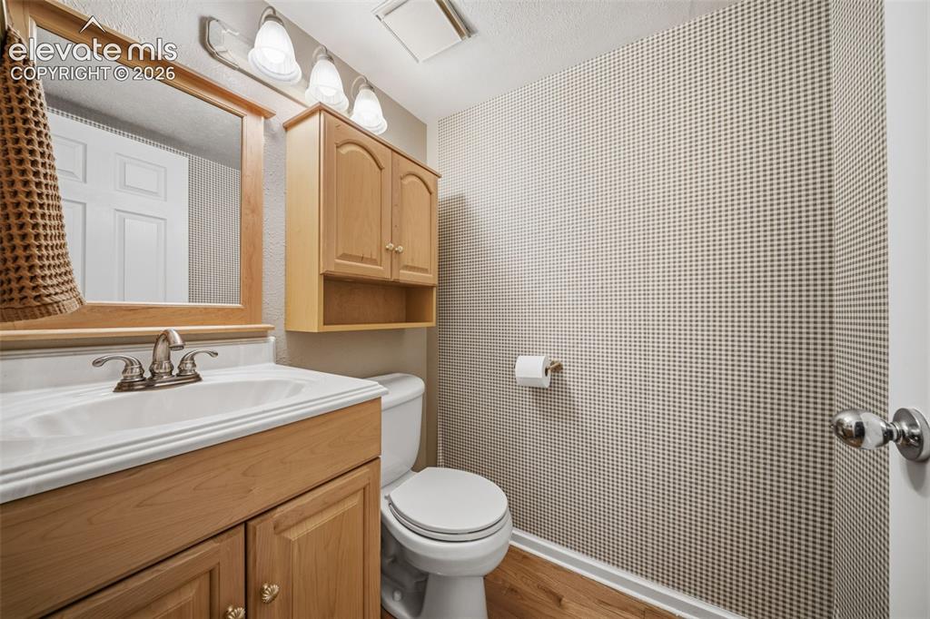 Image 17 of 42: Bathroom featuring a wood-finish vanity with an integrated sink and brushed