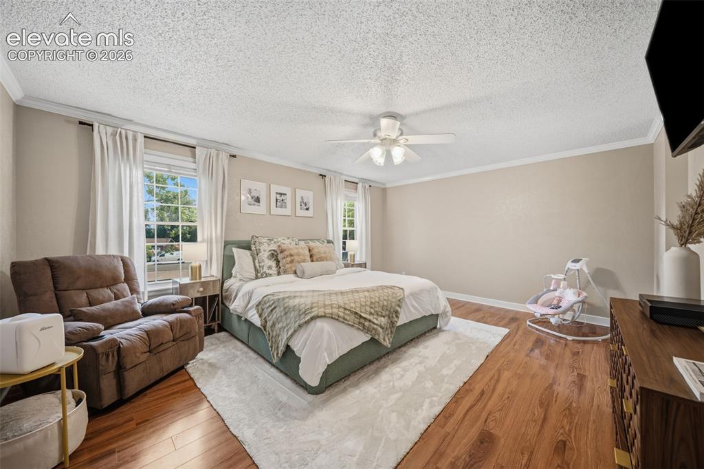 Image 18 of 42: Spacious bedroom featuring wood-finish flooring, light neutral wall paint,