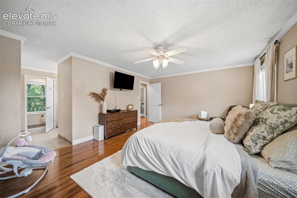 Image 19 of 42: Spacious room featuring wood-finish flooring, neutral wall tones, and crown
