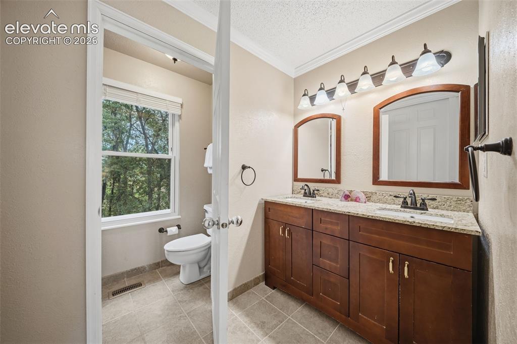 Image 21 of 42: Bathroom featuring a dual vanity with a granite-style countertop, two frame