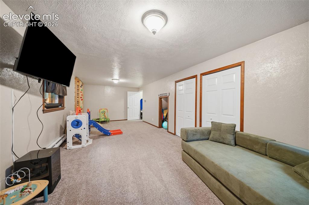 Image 29 of 42: Carpeted recreation area featuring recessed lighting, a mounted television,