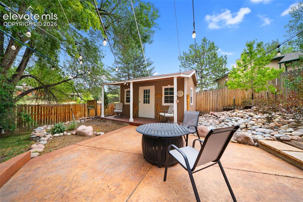 Image 31 of 42: Stamped concrete patio featuring an accessory structure with a covered porc