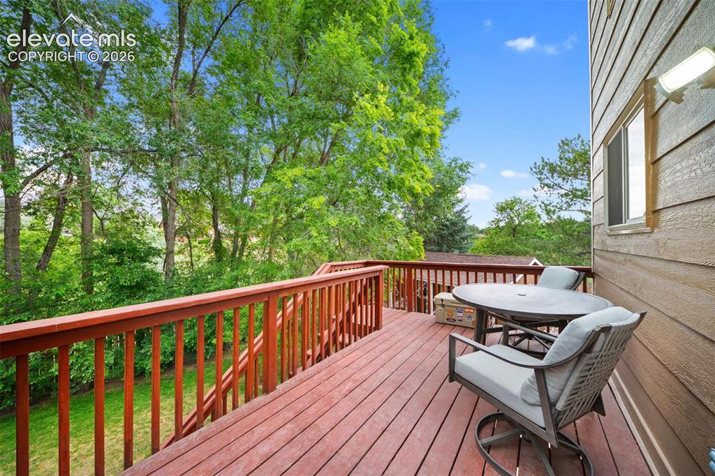 Image 33 of 42: Expansive wood deck with rich red-toned stain, featuring a full railing sys