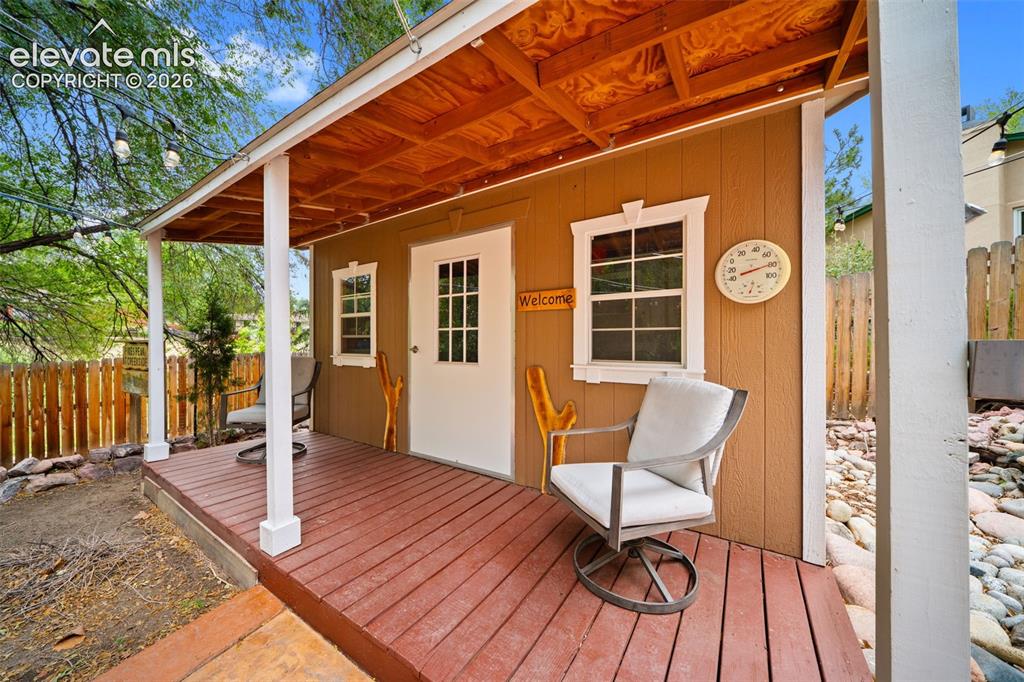 Image 41 of 42: Freestanding outbuilding with a covered porch featuring a wood-finish ceili