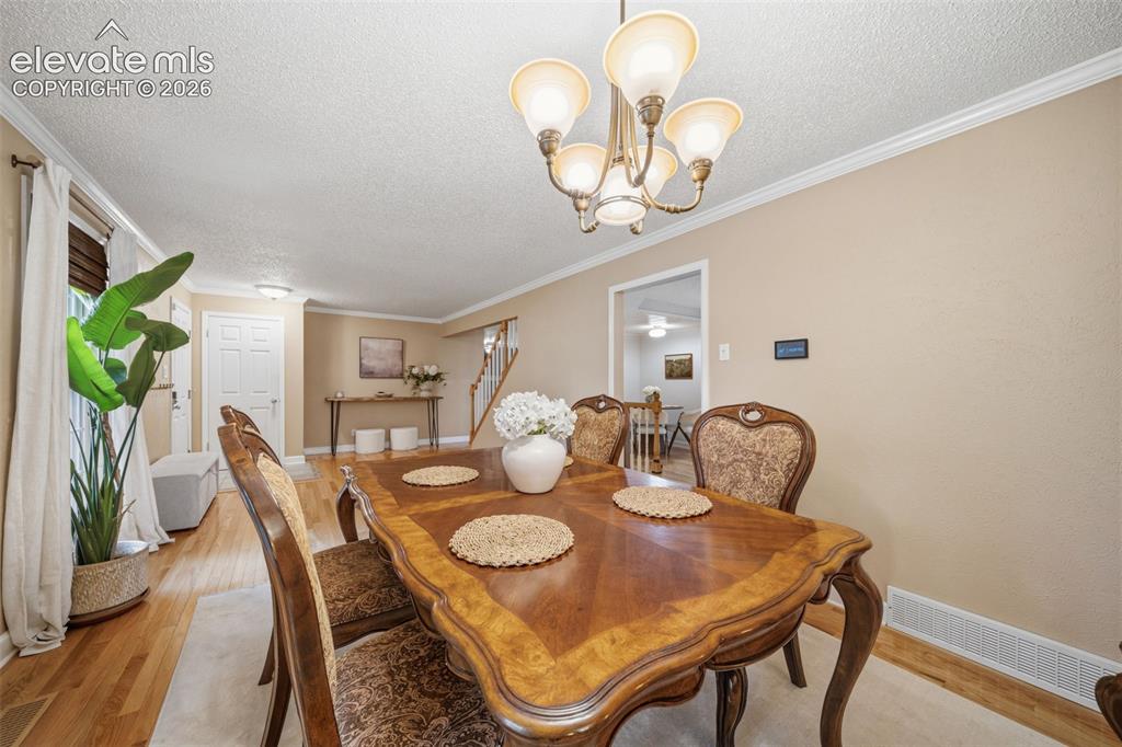Image 7 of 42: Formal dining space featuring wood-finish flooring and crown molding