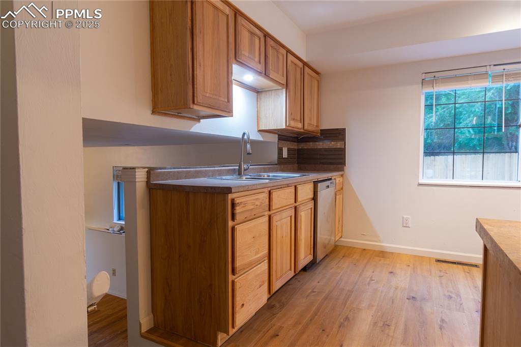 Image 14 of 47: Kitchen featuring light wood-style flooring and stainless steel dishwasher