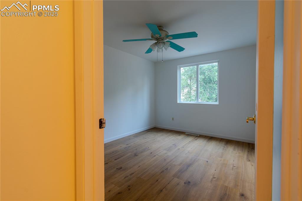 Image 20 of 47: Empty room with wood finished floors and ceiling fan