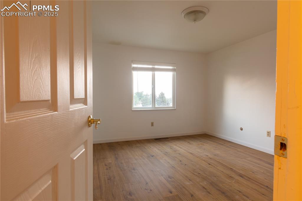 Image 23 of 47: Unfurnished room featuring wood-type flooring and baseboards