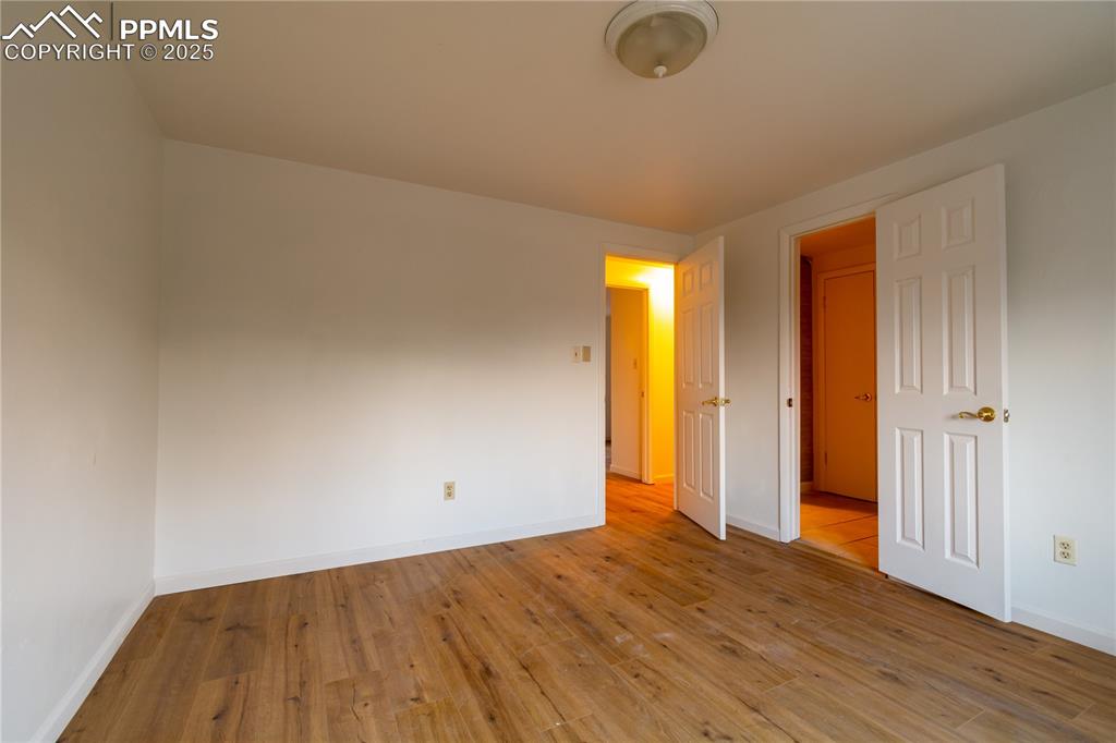 Image 24 of 47: Empty room with light wood-style floors and baseboards