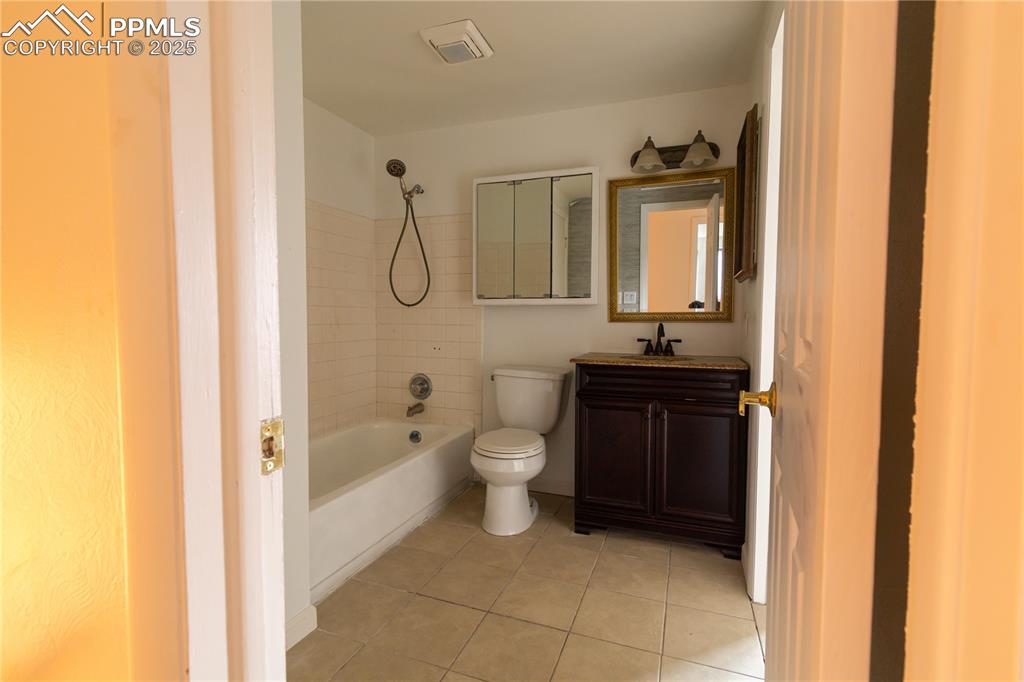 Image 27 of 47: Bathroom featuring tile patterned flooring, shower / tub combination, and v