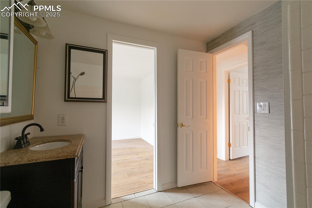 Image 28 of 47: Bathroom with tile patterned flooring and vanity