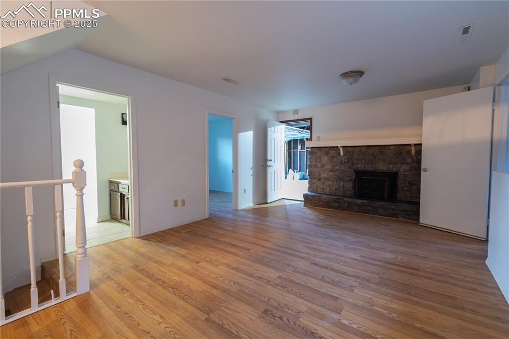 Image 30 of 47: Unfurnished living room featuring light wood finished floors and a fireplac