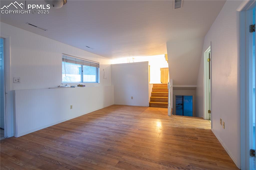 Image 32 of 47: Unfurnished living room featuring wood finished floors and stairs