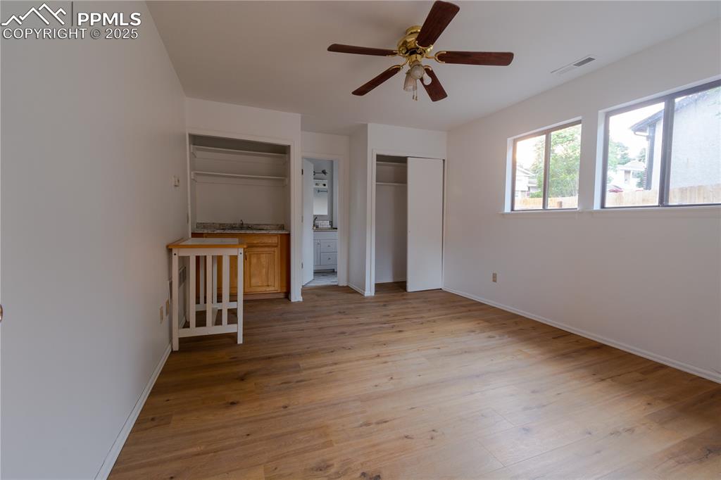 Image 33 of 47: Unfurnished bedroom with light wood-style floors, multiple closets, and a c