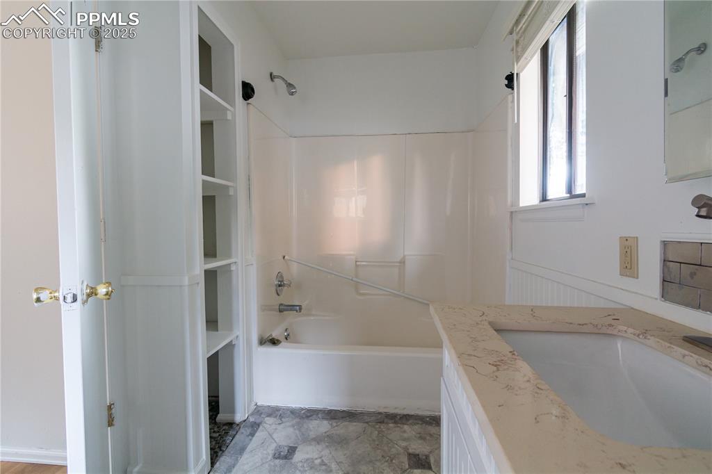 Image 35 of 47: Bathroom featuring tub / shower combination and vanity
