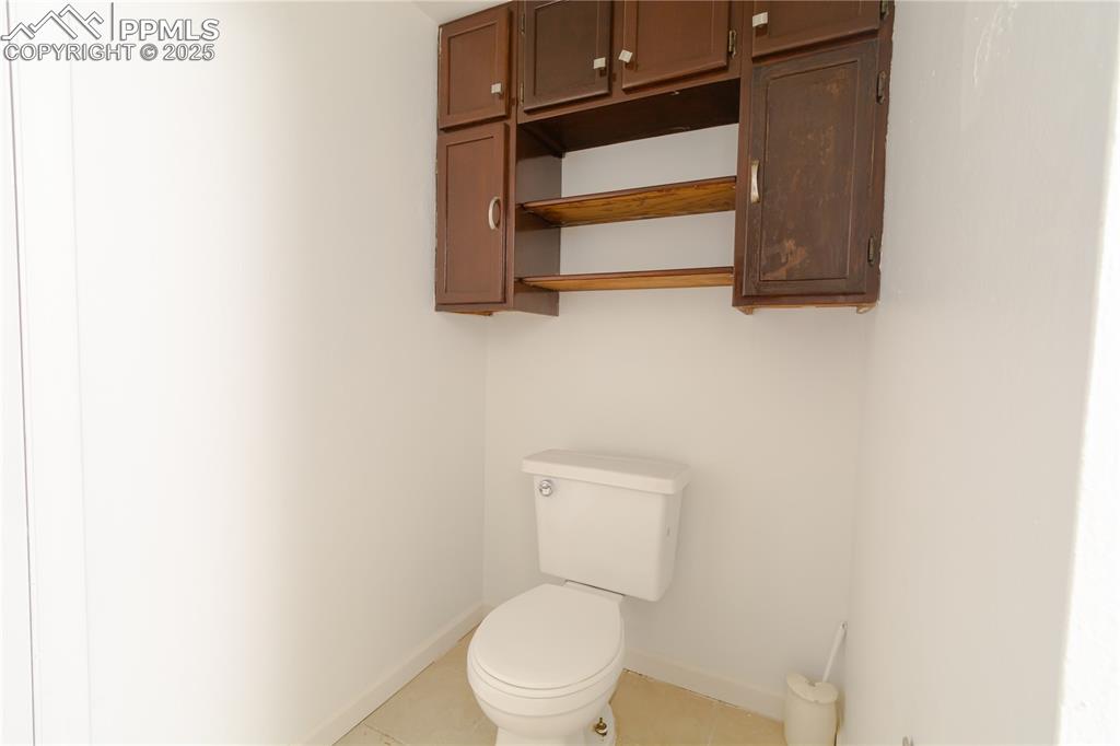 Image 40 of 47: Half bathroom featuring baseboards and tile patterned flooring