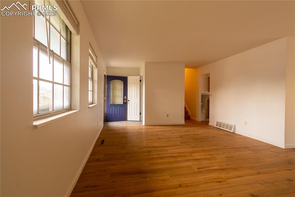 Image 5 of 47: Unfurnished room featuring wood finished floors and stairs