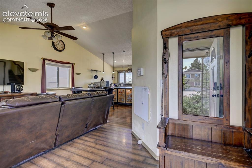 Image 11 of 43: Entryway featuring a built-in wooden bench and framed mirror
