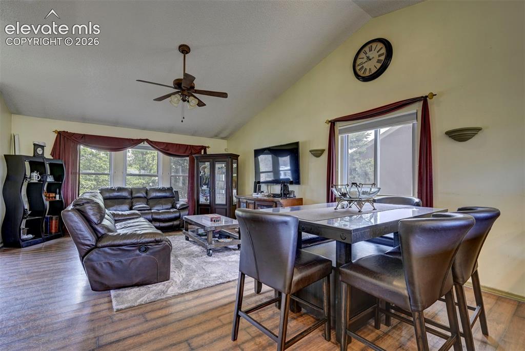 Image 15 of 43: Open-concept living area featuring vaulted ceilings, wood-finish flooring,