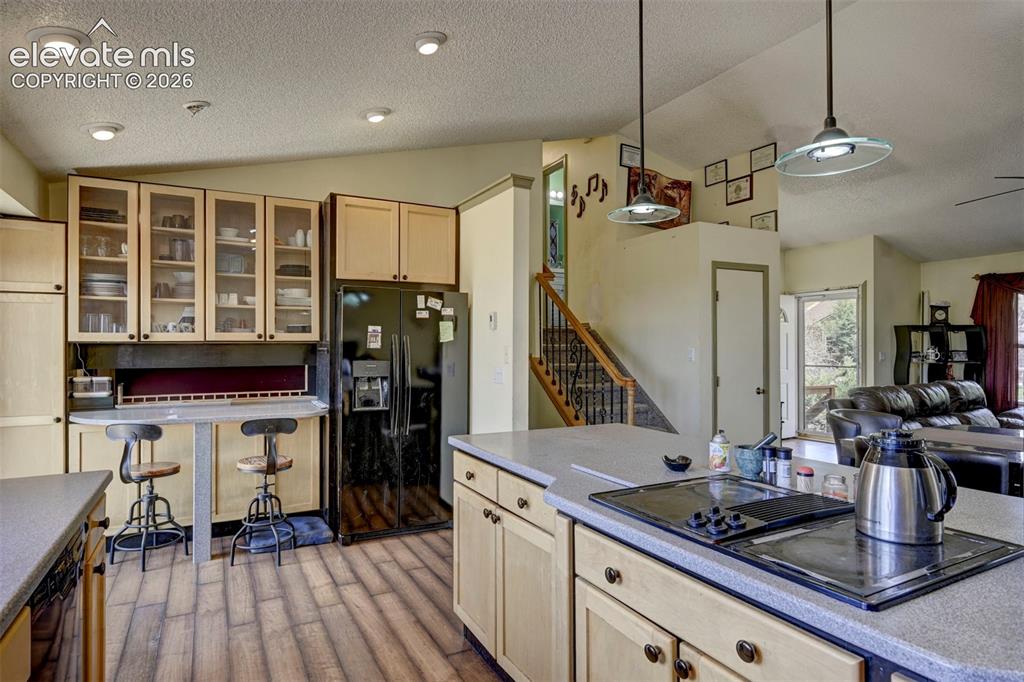 Image 18 of 43: Kitchen featuring wood-finish flooring, recessed lighting, light-toned cabi