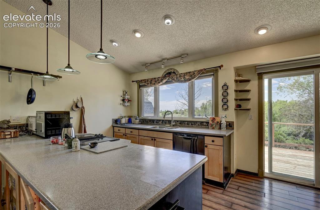 Image 19 of 43: Kitchen featuring a large central island with a speckled countertop, natura