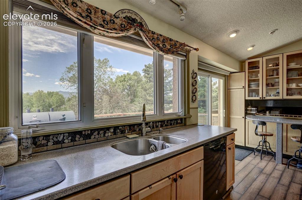 Image 20 of 43: Kitchen featuring a double basin sink, large window with natural light, woo
