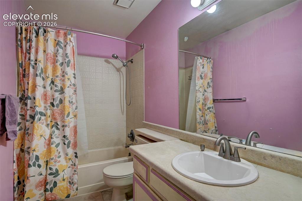 Image 24 of 43: Bathroom featuring a built-in vanity with an oval sink and brushed nickel f