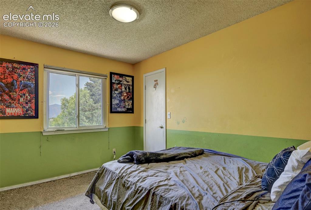 Image 26 of 43: Interior room featuring a large window, textured ceiling, and a flush-mount
