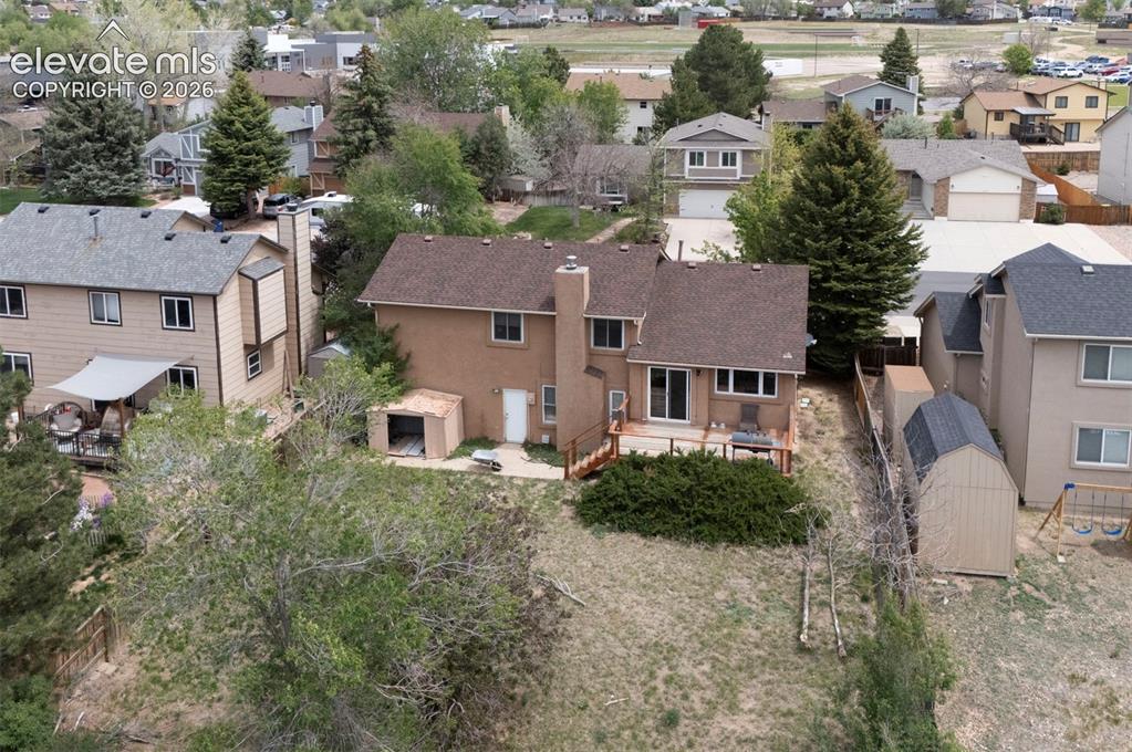 Image 39 of 43: Rear exterior with a wood deck, sliding glass door access, and a stucco fin