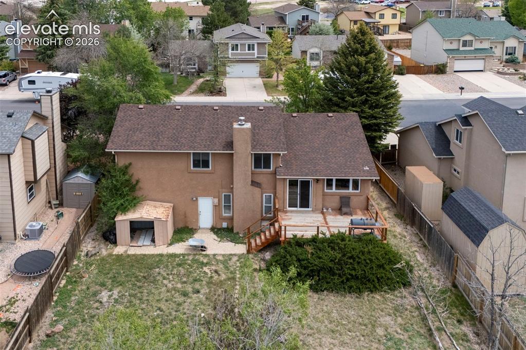 Image 40 of 43: Rear exterior featuring a spacious deck with perimeter railing, ground-leve